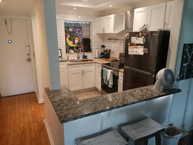 kitchen with white cabinets, light hardwood / wood-style flooring, refrigerator, and stainless steel range with electric stovetop