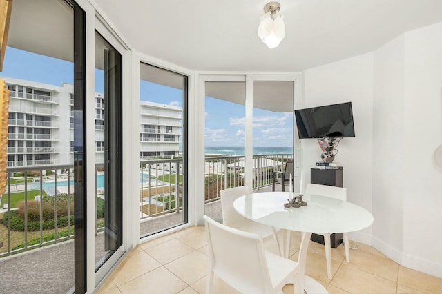 dining space featuring light tile patterned floors and a wall of windows