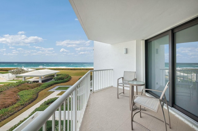 balcony featuring a water view and a view of the beach