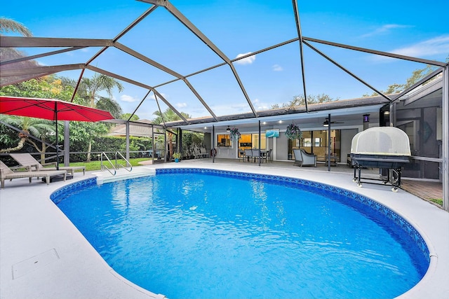 view of pool with ceiling fan, a patio area, and glass enclosure