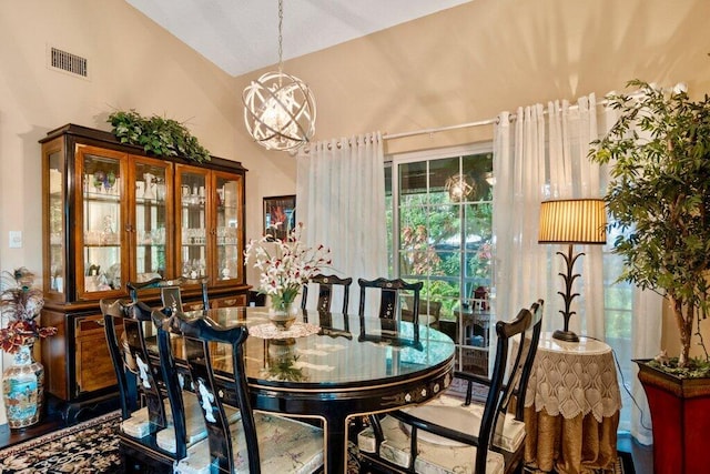 dining space with wood-type flooring, vaulted ceiling, and a notable chandelier