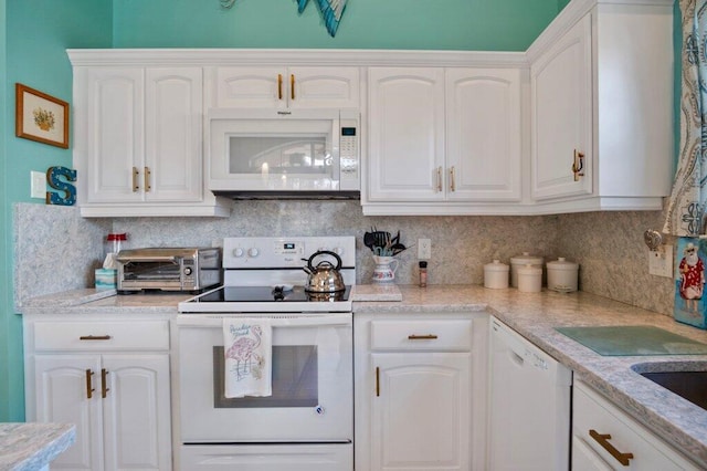 kitchen featuring decorative backsplash, white cabinetry, light stone countertops, and white appliances