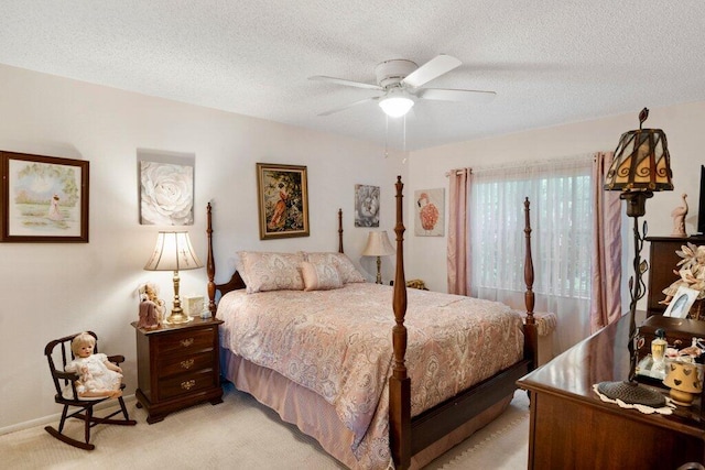 bedroom with a textured ceiling, light colored carpet, and ceiling fan