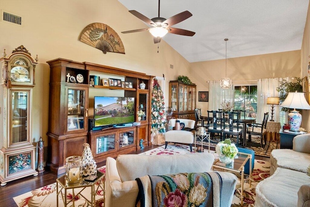 living room featuring ceiling fan with notable chandelier, dark hardwood / wood-style flooring, and high vaulted ceiling