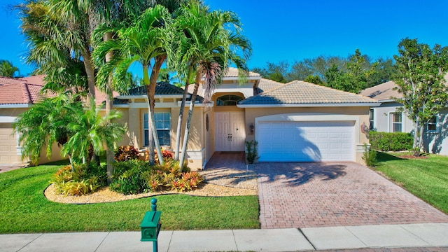 mediterranean / spanish-style house featuring a front lawn and a garage