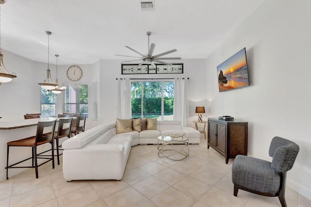 living room featuring light tile patterned floors and ceiling fan with notable chandelier