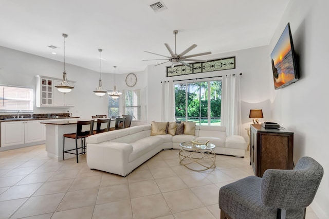 tiled living room with ceiling fan and sink