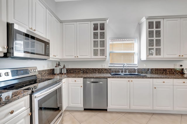 kitchen featuring sink, white cabinets, light tile patterned floors, and appliances with stainless steel finishes