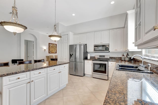 kitchen featuring white cabinetry, sink, decorative light fixtures, and appliances with stainless steel finishes