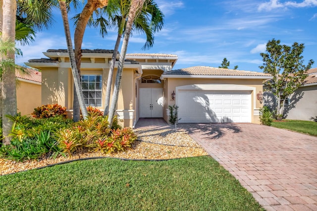 mediterranean / spanish-style house with a garage and a front lawn