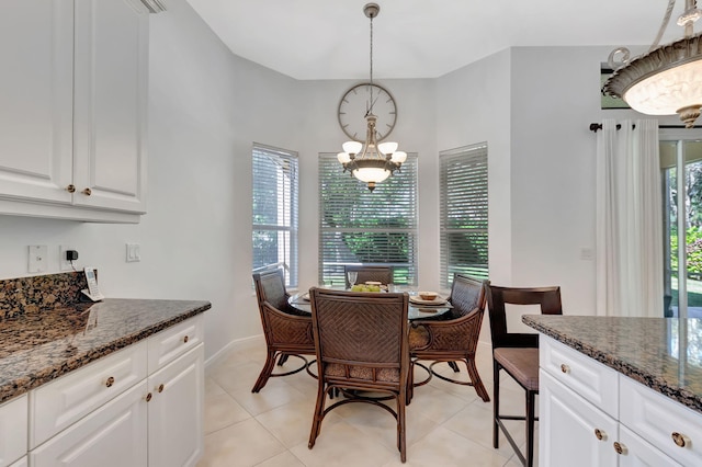 tiled dining room with a chandelier