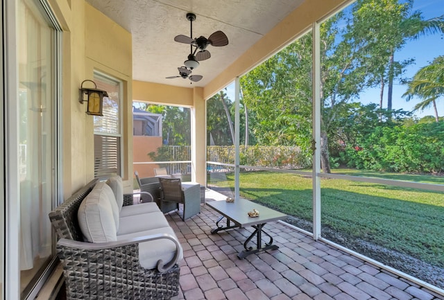 sunroom / solarium featuring ceiling fan