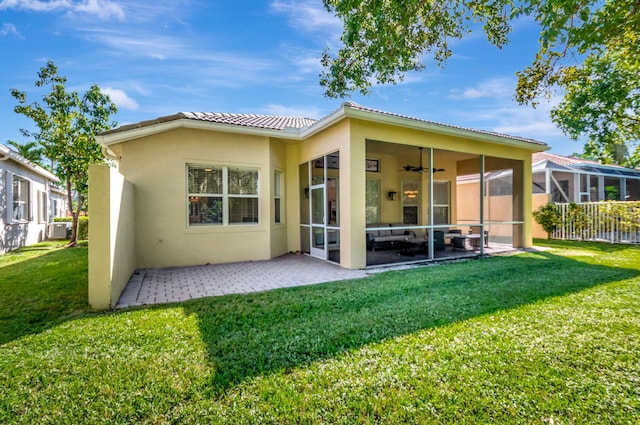 back of property with a sunroom, a yard, and a patio