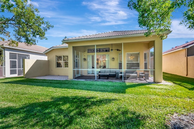 back of house with outdoor lounge area, a patio, ceiling fan, and a lawn