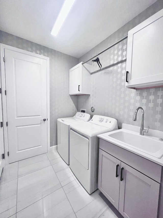 clothes washing area with light tile patterned flooring, cabinets, independent washer and dryer, and sink