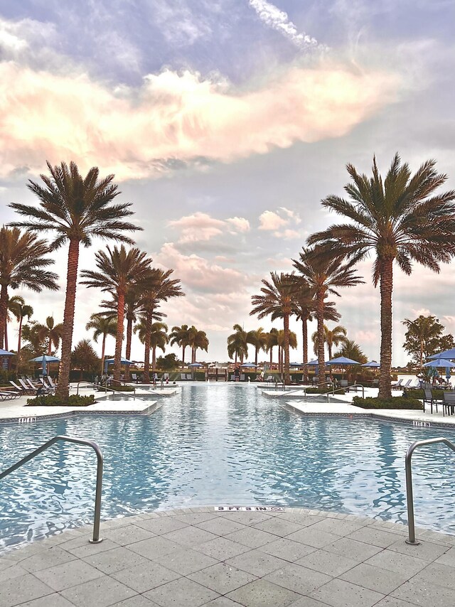 pool at dusk with a patio