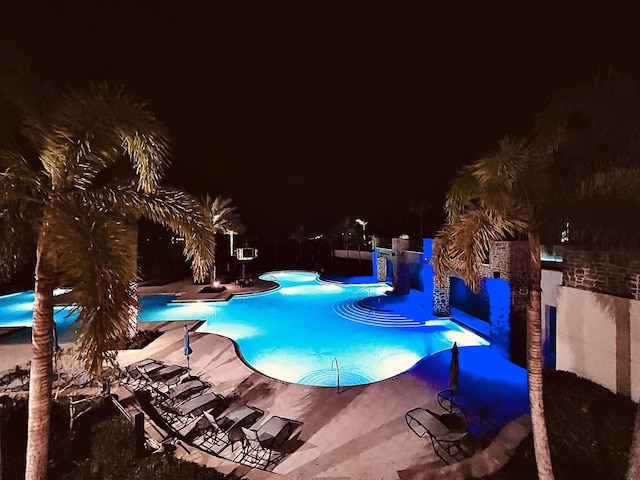 pool at twilight with a patio area