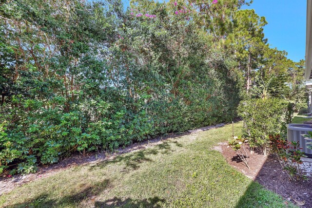 property entrance featuring central AC unit and a lawn