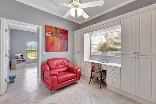 home office featuring ornamental molding, built in desk, and a ceiling fan