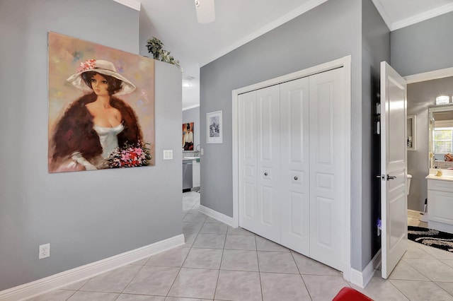 interior space with baseboards, crown molding, and light tile patterned flooring