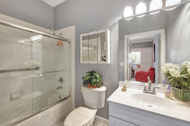 full bath with baseboards, connected bathroom, toilet, enclosed tub / shower combo, and vanity