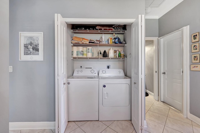 laundry room featuring light tile patterned flooring, washing machine and dryer, laundry area, visible vents, and baseboards