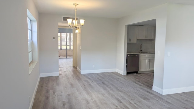 interior space with light hardwood / wood-style floors, sink, and a chandelier