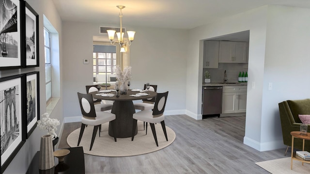 681 Flanders O, Delray Beach, FL 33484 - dining area featuring a chandelier, light wood-style flooring, and baseboards