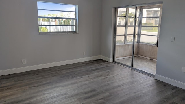 unfurnished room featuring dark hardwood / wood-style flooring and a wealth of natural light