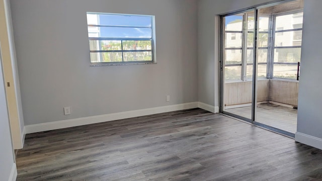 unfurnished room with plenty of natural light and dark wood-type flooring