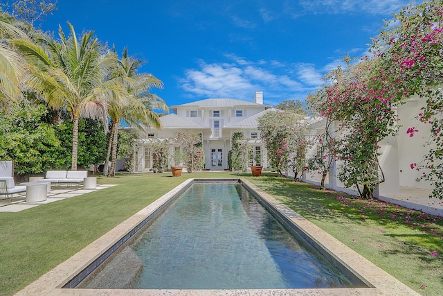 view of pool with a lawn, a patio area, and french doors