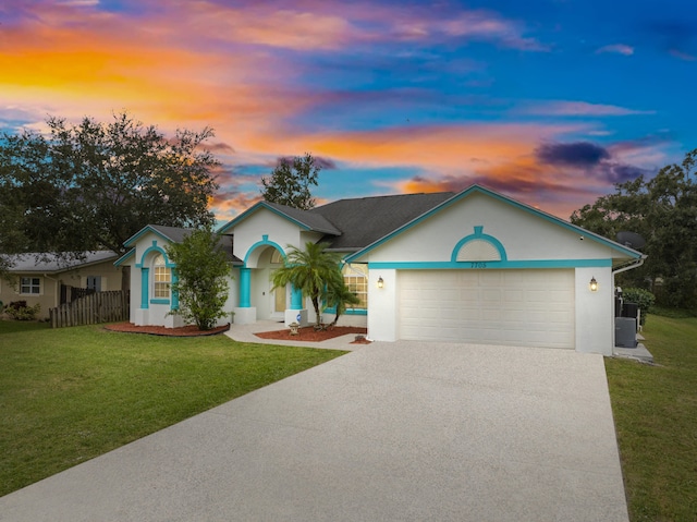 ranch-style home featuring a lawn and a garage