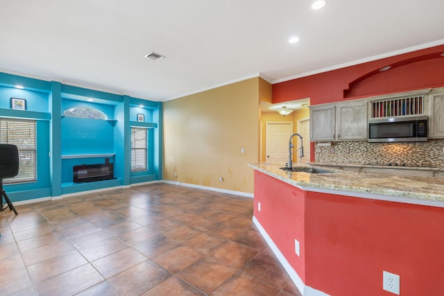 kitchen featuring dark tile patterned floors, ornamental molding, sink, and tasteful backsplash