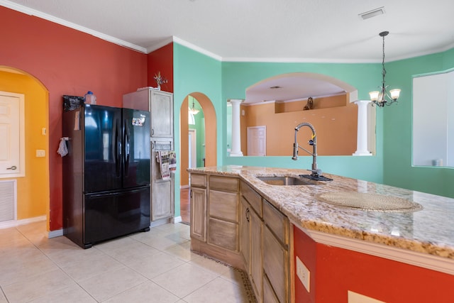 kitchen featuring sink, an inviting chandelier, crown molding, pendant lighting, and black refrigerator