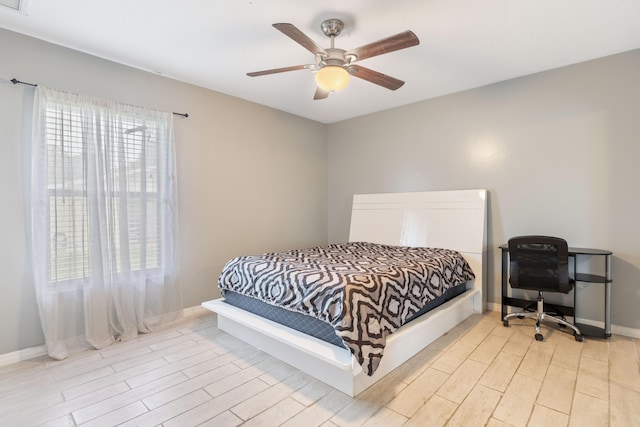 bedroom with multiple windows, ceiling fan, and light wood-type flooring