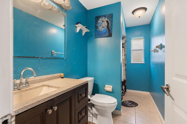 bathroom featuring tile patterned flooring, vanity, and toilet