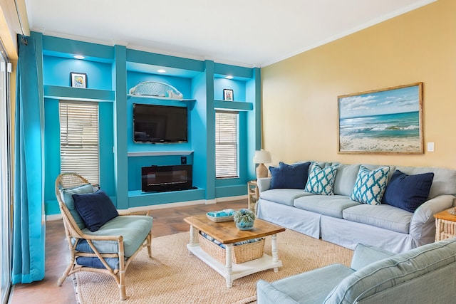 living room with hardwood / wood-style flooring, built in features, and crown molding