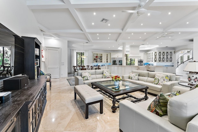 living room featuring beamed ceiling, ceiling fan, and coffered ceiling