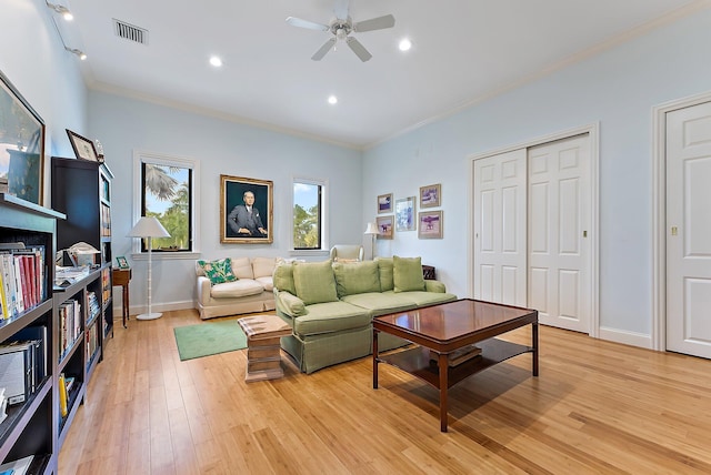 living room with ceiling fan, light wood-type flooring, track lighting, and crown molding