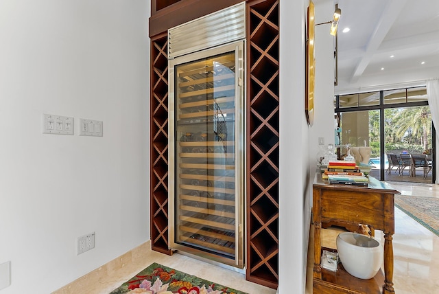 wine room featuring beverage cooler, coffered ceiling, beamed ceiling, and bar