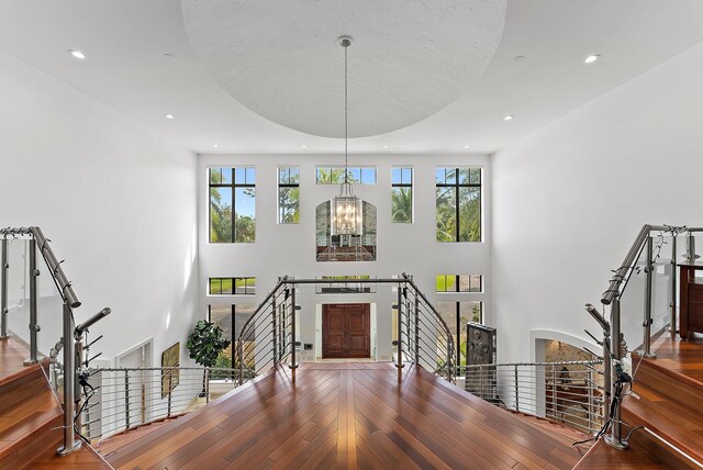 interior space featuring a high ceiling, an inviting chandelier, and hardwood / wood-style flooring