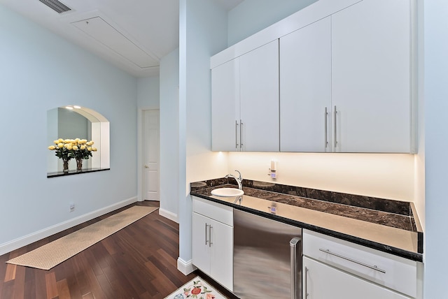 kitchen featuring sink, fridge, white cabinets, and dark wood-type flooring