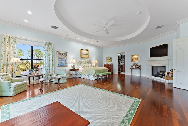 bedroom featuring a raised ceiling, crown molding, and wood-type flooring