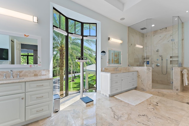 bathroom featuring a shower with shower door, a wealth of natural light, and vanity