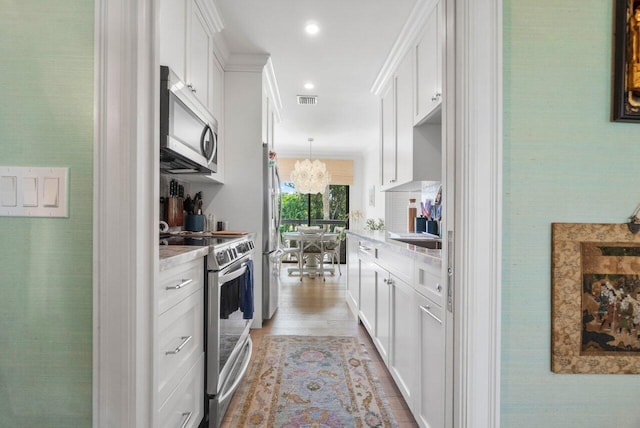 kitchen featuring light stone countertops, white cabinets, and appliances with stainless steel finishes