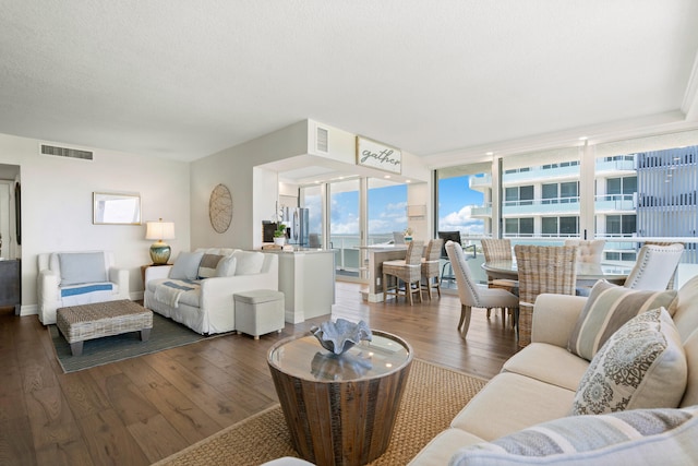 living room featuring a textured ceiling, dark hardwood / wood-style floors, and expansive windows