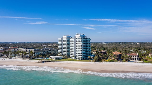 birds eye view of property featuring a water view and a beach view