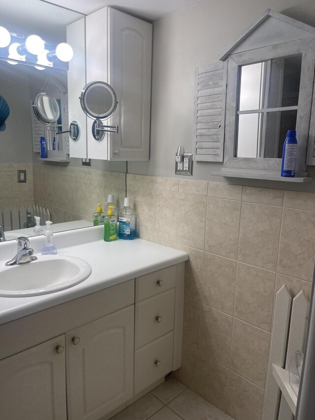 bathroom with tile patterned floors, vanity, and tile walls