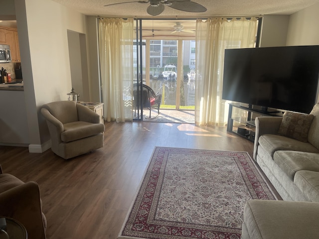 living room featuring hardwood / wood-style flooring, ceiling fan, a textured ceiling, and a wall of windows