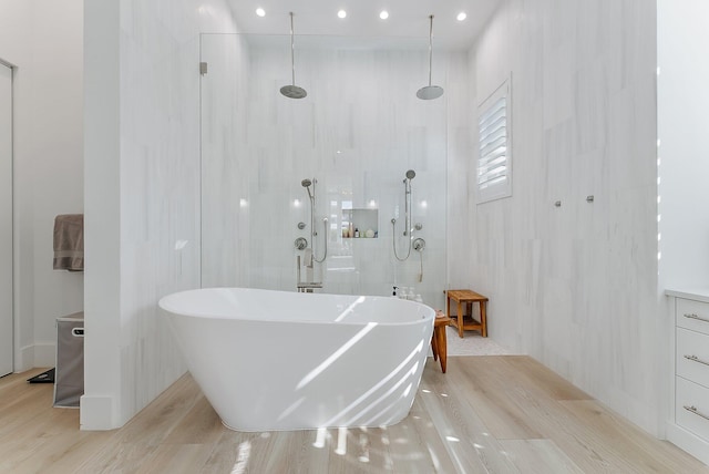 bathroom with hardwood / wood-style floors and plus walk in shower